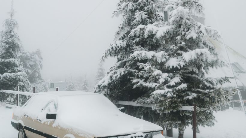 A snow covered car in winter